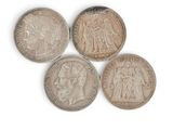 four silver coins of different sizes and shapes on a white surface