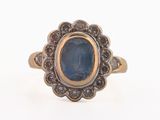 an image of a gold ring with a blue stone in the center