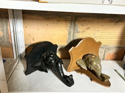 two masks that are sitting on a shelf next to each other