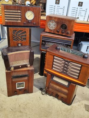 many old radio ' s sitting on the floor in a room