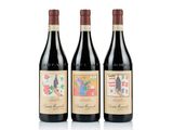 trois bouteilles de vin rouge sont alignées sur une surface blanche