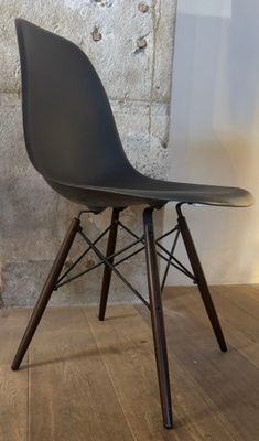 a black chair with a wooden leg and a black seat