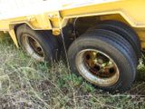 a yellow truck that is sitting in the grass