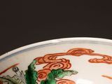 a white bowl with orange and green designs on it