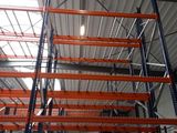 many shelves that are in a warehouse with a skylight above them
