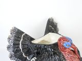 a black turkey figurine with a red and blue bird on it ' s head