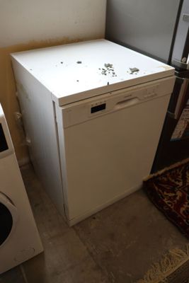 an image of a kitchen with a refrigerator and a washing machine