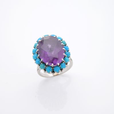 un gros plan d'une bague ornée d'une pierre violette entourée de pierres turquoise