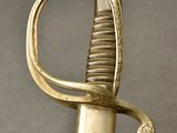 an old sword with a gold handle on a gray surface