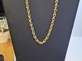 un collier à chaîne en or posé sur un présentoir noir pour mannequin