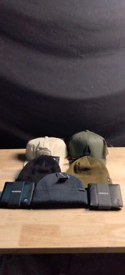 three hats and a wallet sitting on a wooden table