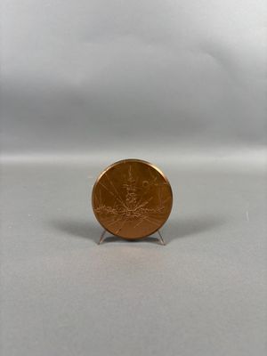 une petite pièce posée sur un petit socle, sur une surface blanche