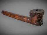 une vieille pipe avec un tuyau en bois sur fond gris