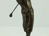 statue en bronze représentant un homme brandissant un club de golf, posée sur un socle