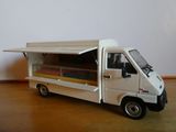 un petit camion blanc avec un chariot de restauration à l'arrière