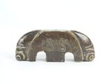 a small elephant figurine sitting on a white surface
