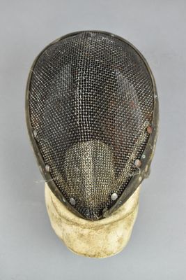 a close up of a fencing mask on a white surface