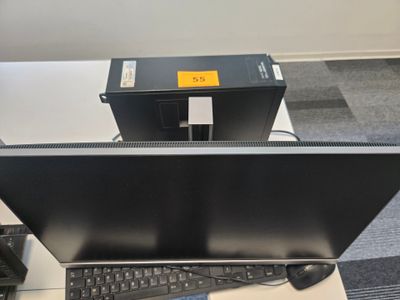 un écran d'ordinateur posé sur un bureau à côté d'un clavier