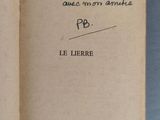 un livre ouvert avec une écriture dessus, posé sur une table