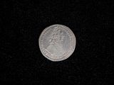 a close up of a silver coin on a black surface