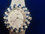 an image of a woman ' s wrist watch with blue and white stones