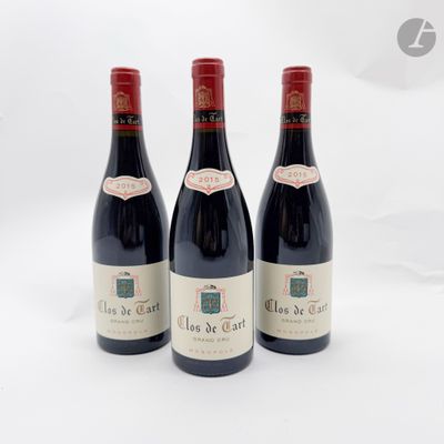 trois bouteilles de vin rouge posées sur une table blanche