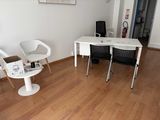 a white table and chairs in a room with wood flooring