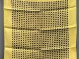 un mouchoir jaune à pois noirs suspendu à une corde à linge