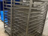 an image of a metal rack with several trays of food on it