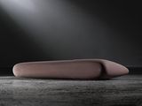 a pink object sitting on the floor with a light coming through it
