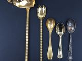 five spoons and a ladle on a blue surface