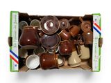 une boîte en carton remplie de tasses à café et de soucoupes