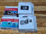 boxes of cameras sitting on a wooden surface next to each other