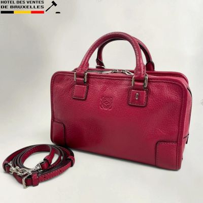 a red handbag with a leash on a white background