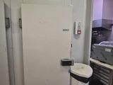a white refrigerator and a trash can in a kitchen