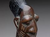 an image of a wooden sculpture of a man with a hat on his head
