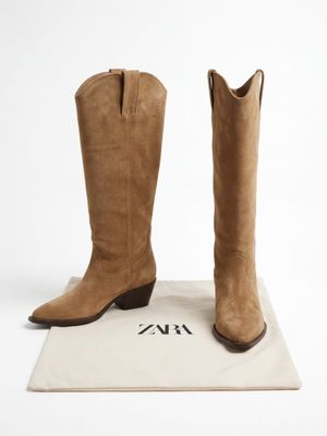 des bottes de cow-boy couleur beige sur fond blanc