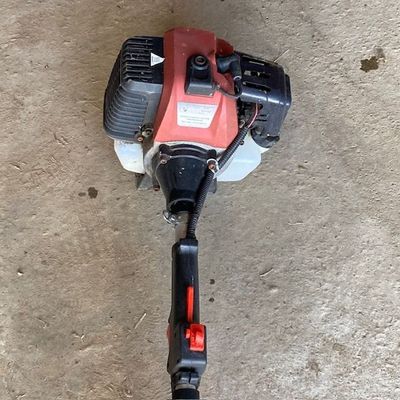 un petit moteur rouge et noir posé au sol