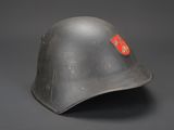 an old german steel helmet with a red emblem on the side