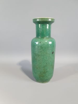 a small green vase sitting on a white surface