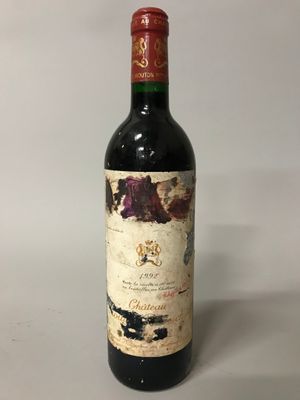 an old bottle of wine sitting on top of a white table