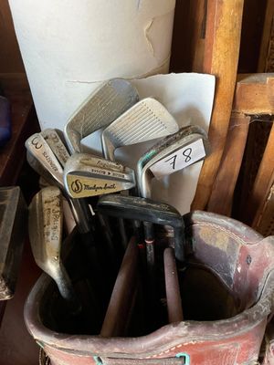 a bucket full of golf clubs sitting on a table