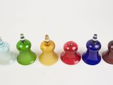several different colored bottles are lined up on a white surface