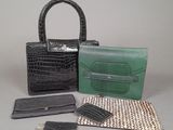 two purses, a wallet, and a card case are sitting on a table