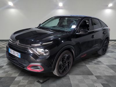 la voiture noire est garée sur un sol en damier dans le garage