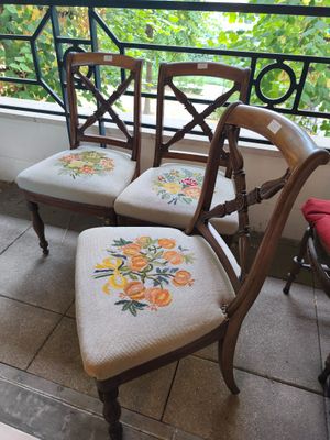two chairs that are sitting on a balcony near a window
