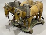 two horses pulling a sleigh with a man on it