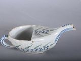 a small blue and white bird shaped bowl on a table