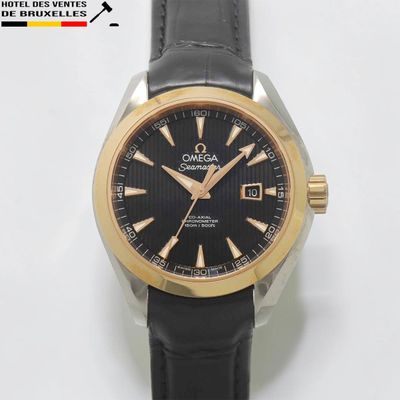 gros plan d'une montre sur une surface blanche avec un bracelet noir