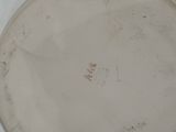 a white plate that has a brown design on it